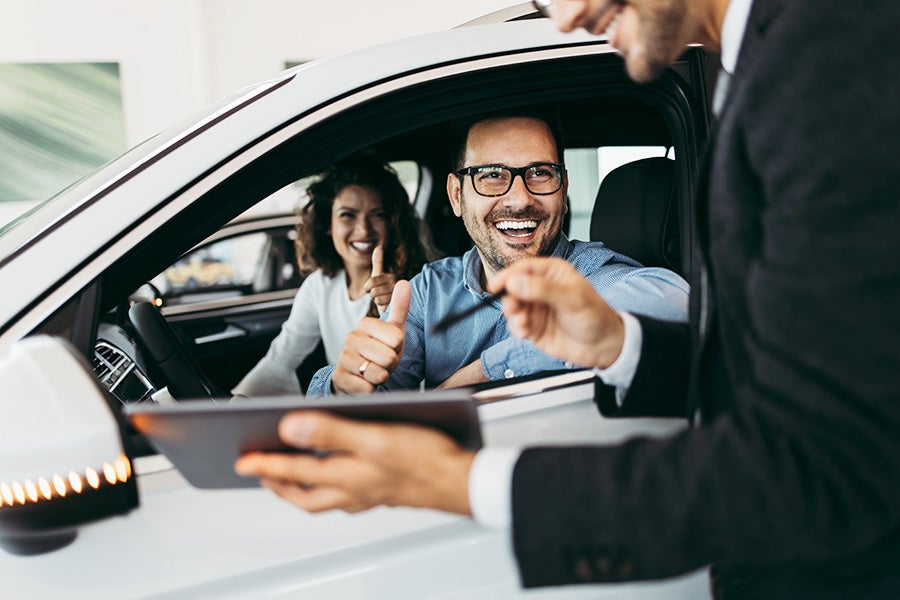 Customer reviewing vehicle details with dealership representative during a car purchase